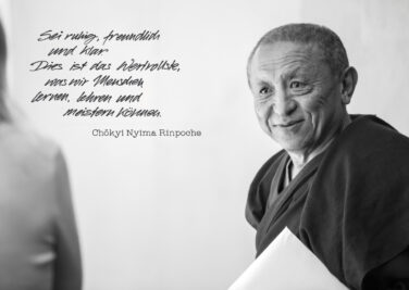 Chokyi Nyima Rinpoche blickt aufmerksam eine Schülerin an